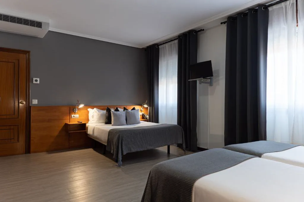 Habitación con cortinas oscuras y televisión de pantalla plana, Hotel & Spa Carlos desde 1996