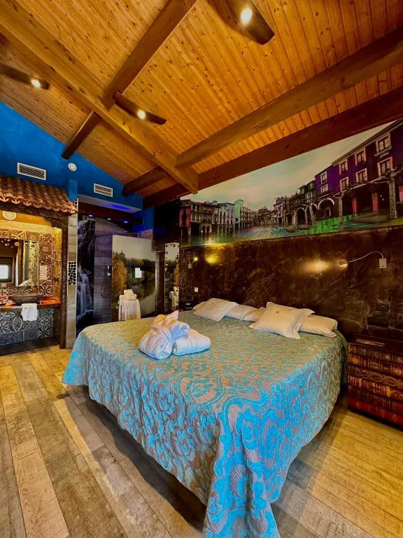 Habitación de tonos turquesa con cabecero de madera y barricas al fondo