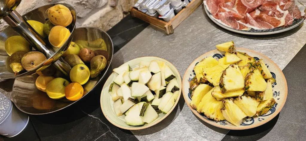 Buffet con fruta, queso y platos calientes