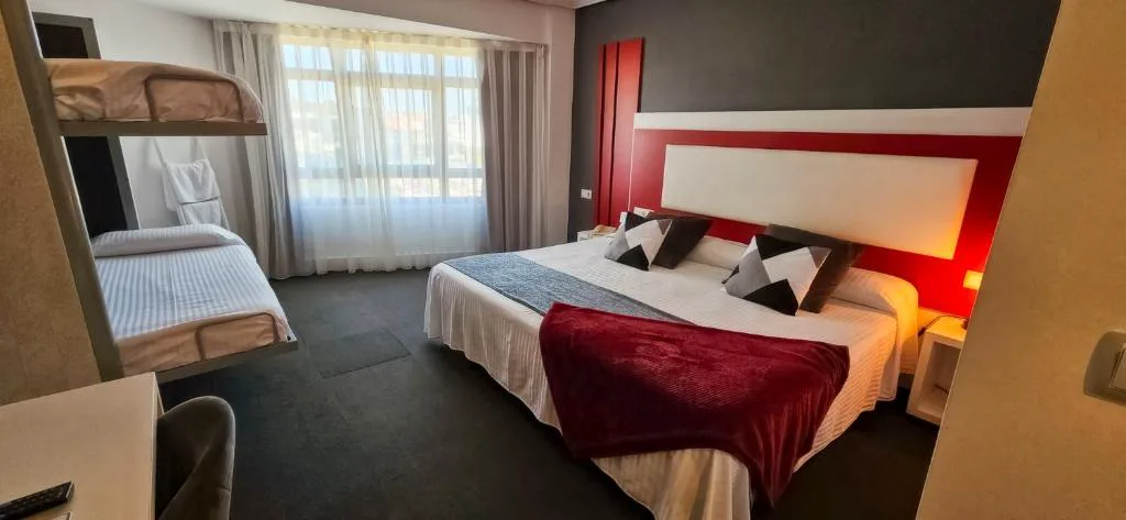 Habitación con cama doble y literas