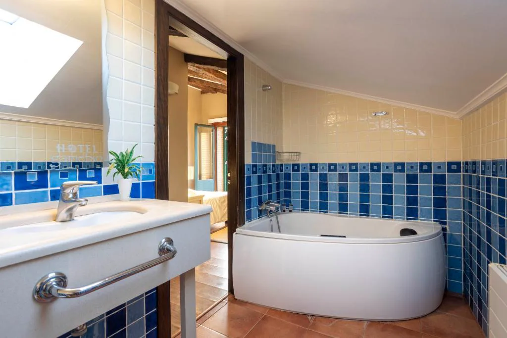 Baño con bañera de hidromasaje esquinera y azulejos azules