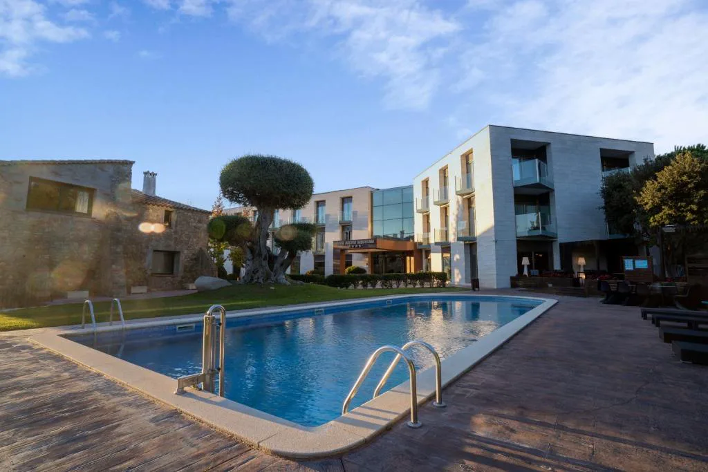 Piscina exterior con tumbonas junto al edificio del hotel