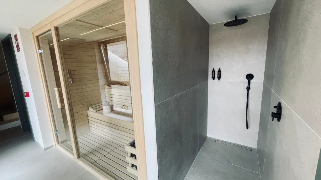 Sauna de madera junto a una ducha de lluvia