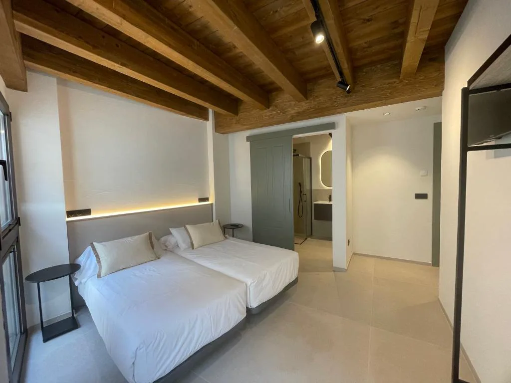 Habitación con techo de madera y baño integrado