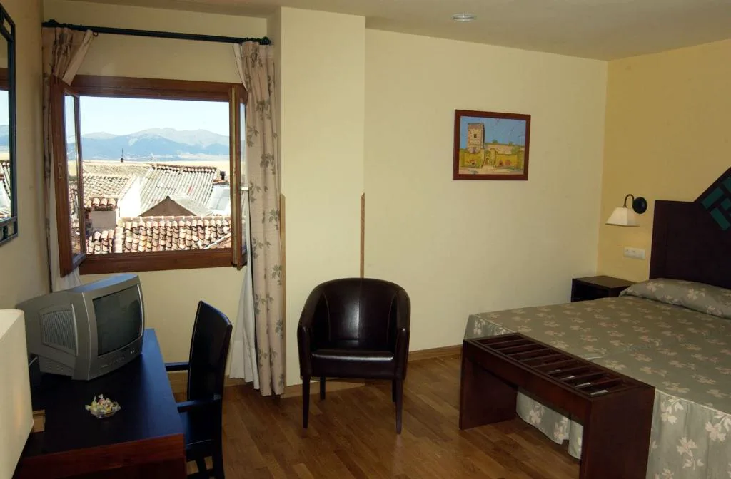 Habitación con ventana, cama y sillón de cuero negro