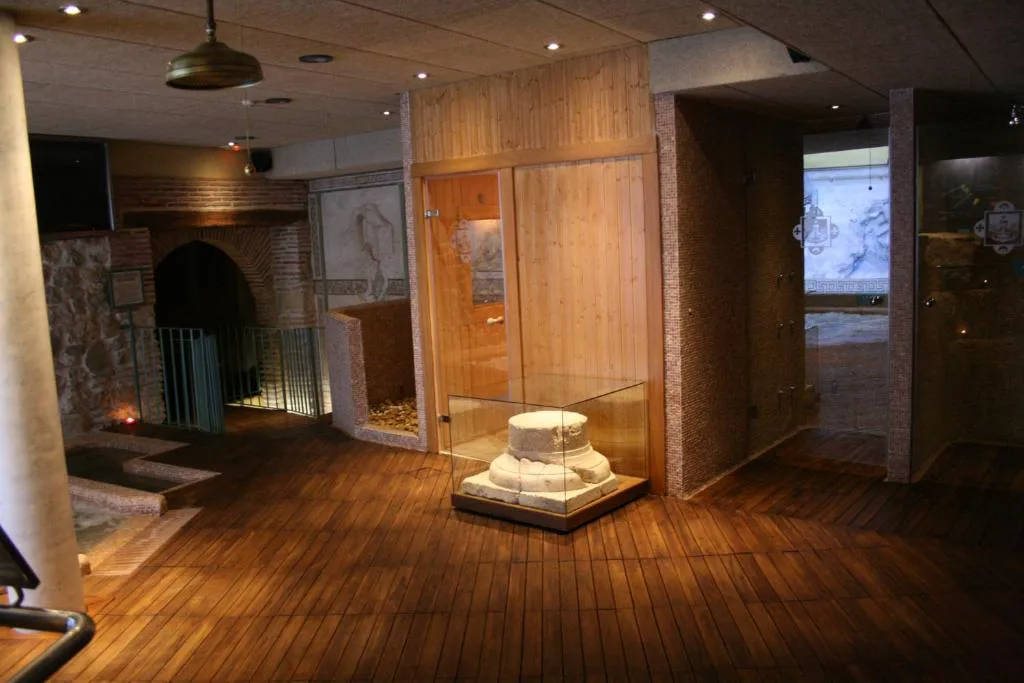 Sala del spa con suelo de madera y vestigios de piedra