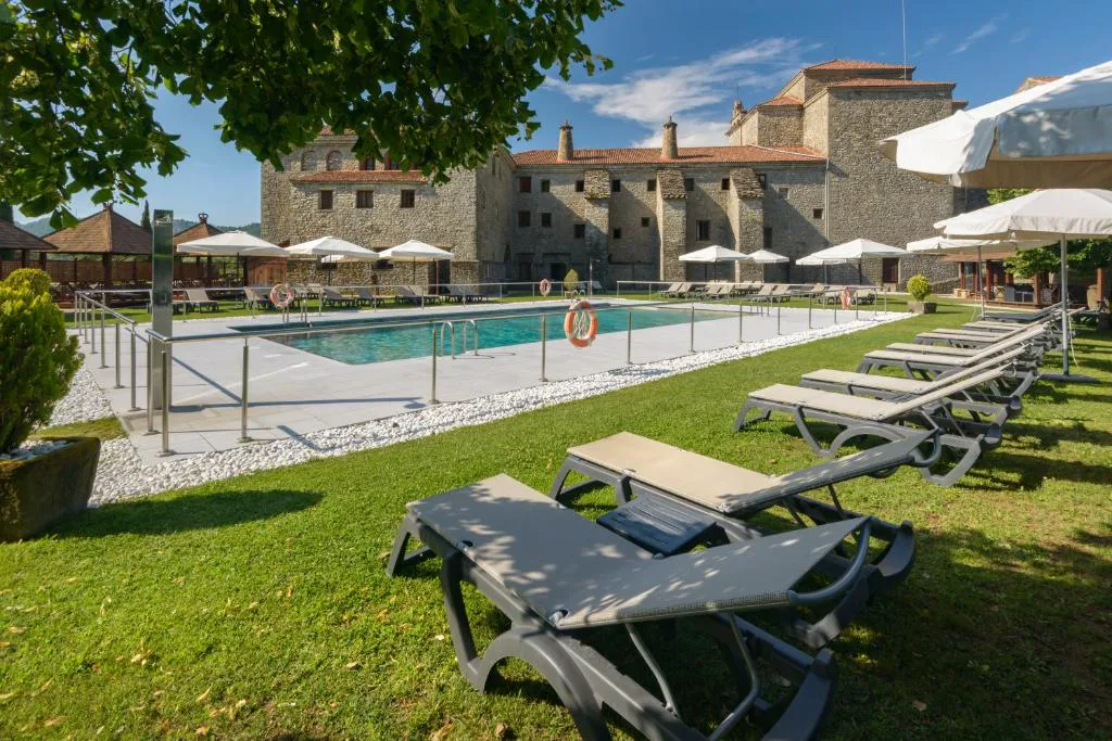 Piscina exterior con tumbonas frente al monasterio