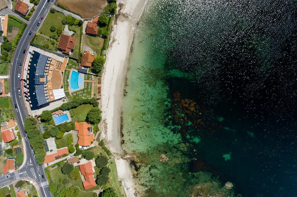 Vista aérea de la piscina exterior del hotel junto a la playa de Nanín