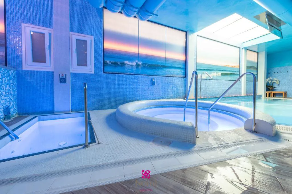 Bañera de hidromasaje circular con chorros junto a la piscina del spa, Hotel Spa Norat O Grove