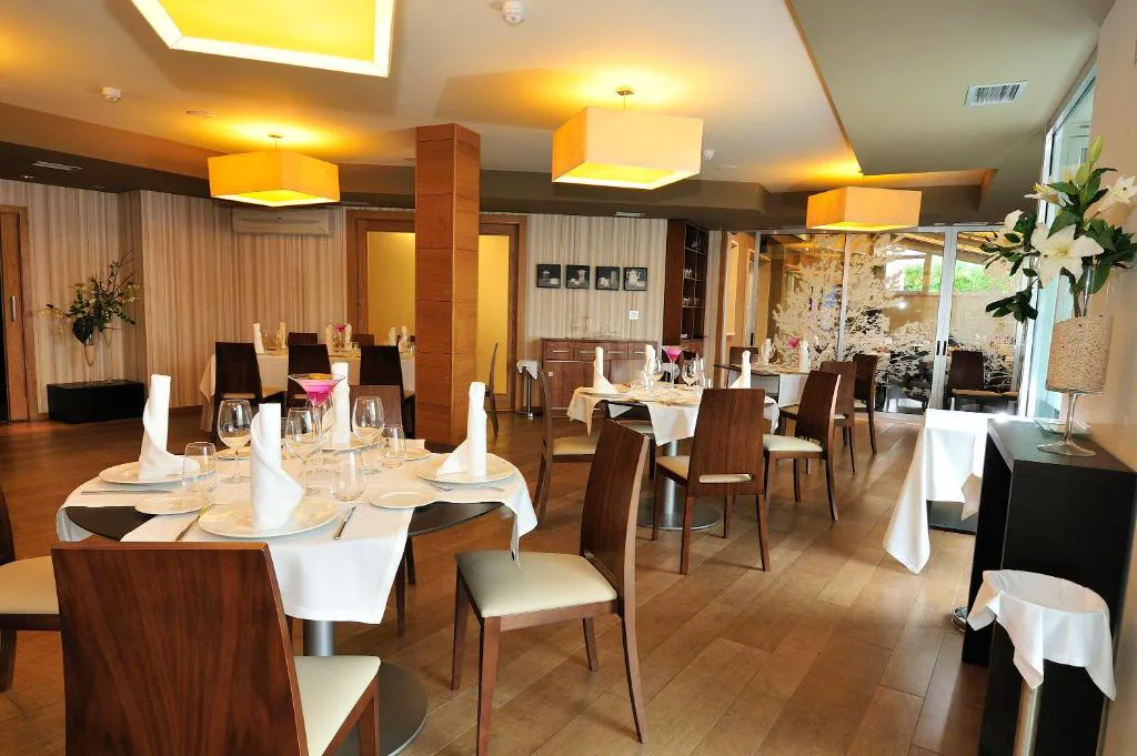 Comedor del restaurante con mesas puestas y ambiente cálido, Hotel Spa Norat O Grove