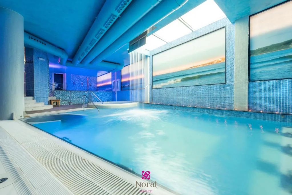 Piscina de hidroterapia con chorros bajo techo azul, Hotel Spa Norat O Grove