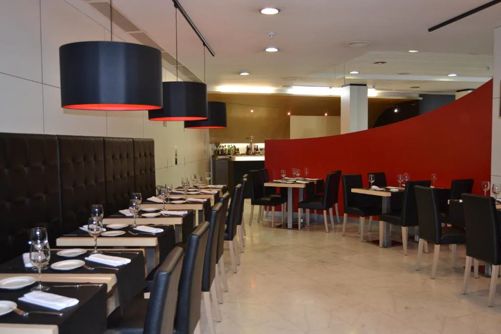 Restaurante de diseño con pared roja y lámparas colgantes, Hotel Spa Odeón