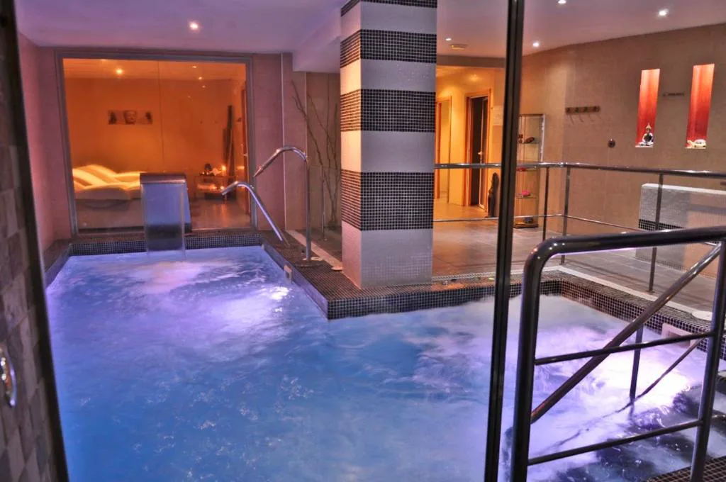 Piscina de spa con luz violeta y escalera de acceso