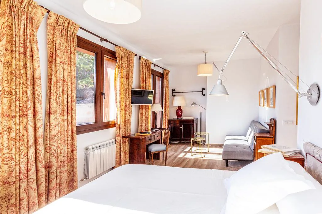 Habitación luminosa con cama blanca y ventanas
