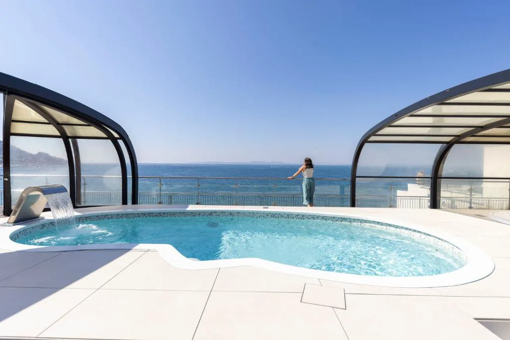 Jacuzzi bajo cubierta retráctil frente al mar