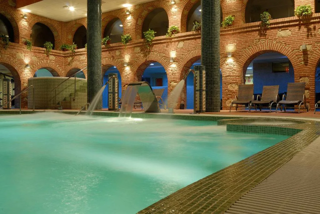 Piscina cubierta con arcos de ladrillo y tumbonas