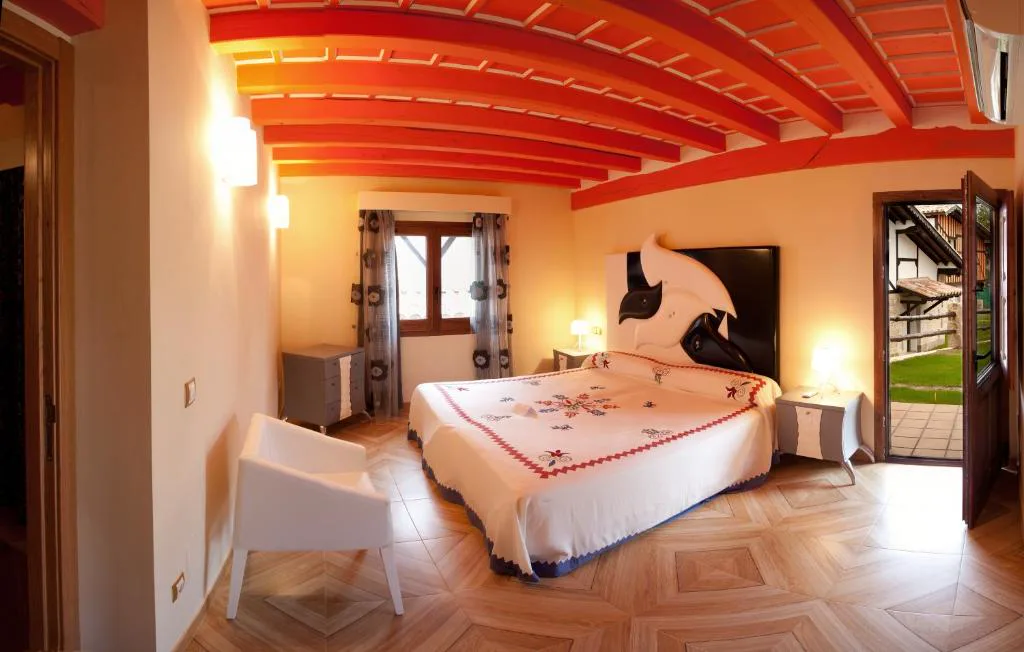 Habitación de techo de vigas rojas con cama y decoración de rosas