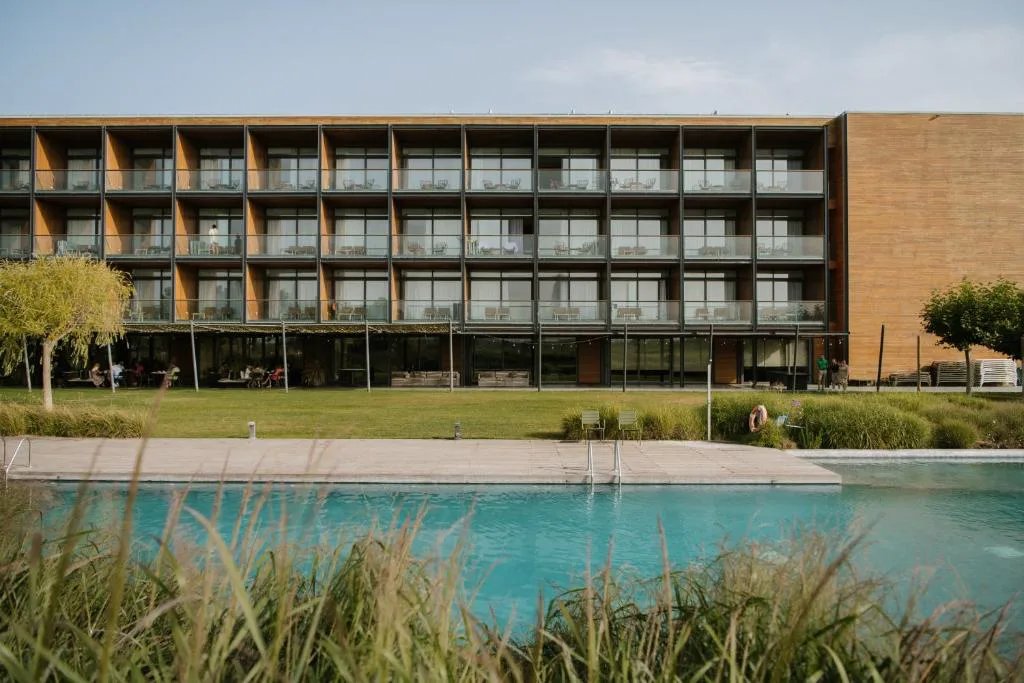Hotel con piscina reflejada frente al campo de golf