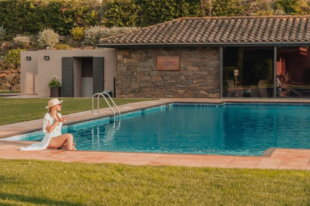Piscina con tumbona y casita de piedra