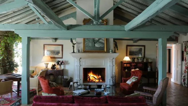 Salón con chimenea y sofás junto a un ventanal
