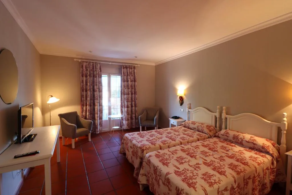 Habitación con colcha rosa y cabecero de madera