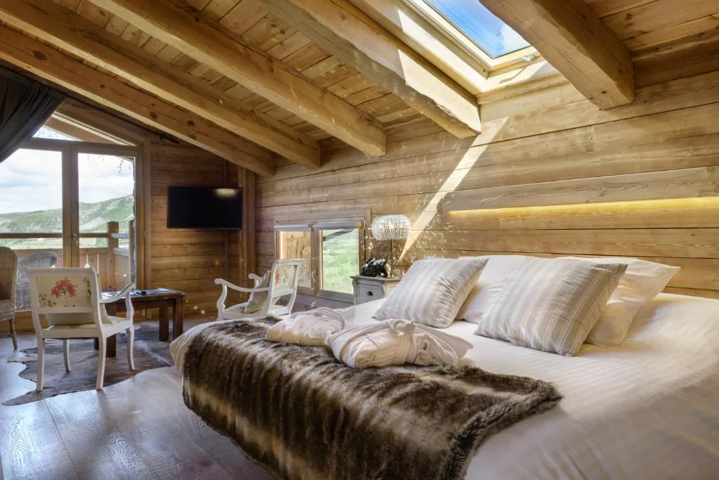 Habitación con techo de madera y cama con mantas