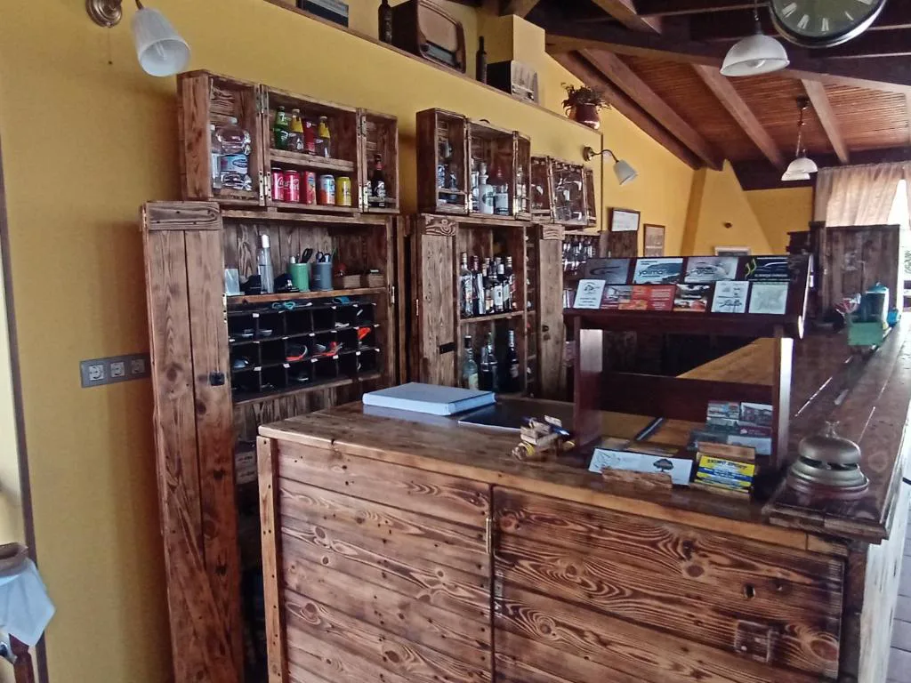 Recepción con mostrador de madera y estantes de botellas