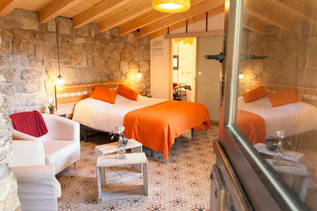 Habitación de piedra con cama y detalles naranjas