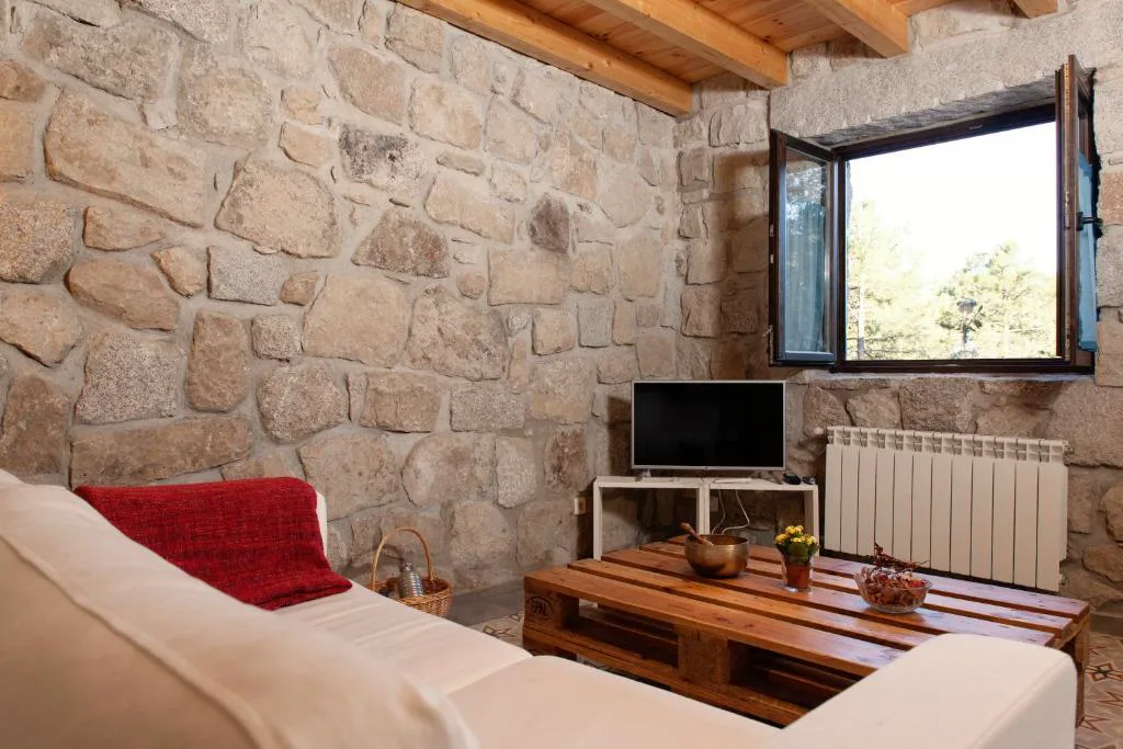 Salón con sofá blanco y pared de piedra