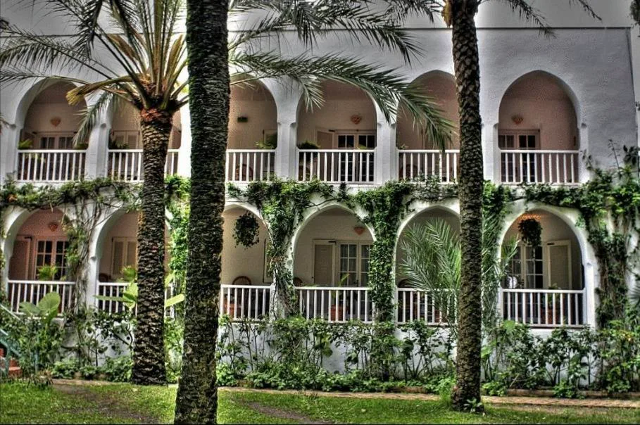 Galería de arcos cubiertos de hiedra con fachada