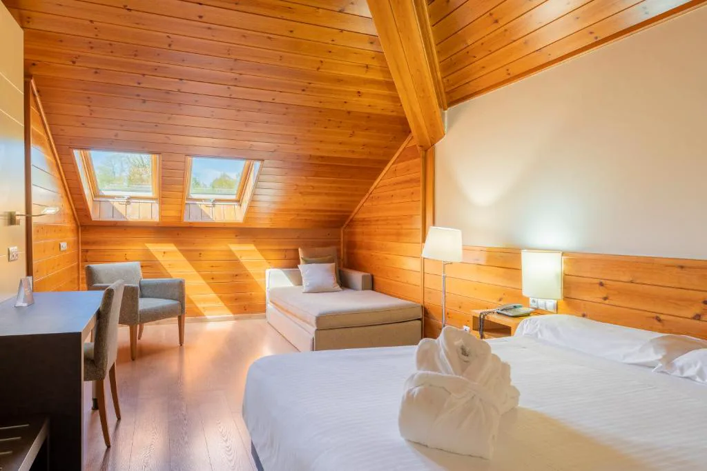 Habitación abuhardillada de madera con ventanas de tejado y chaise longue, IBERIK Augas Santas