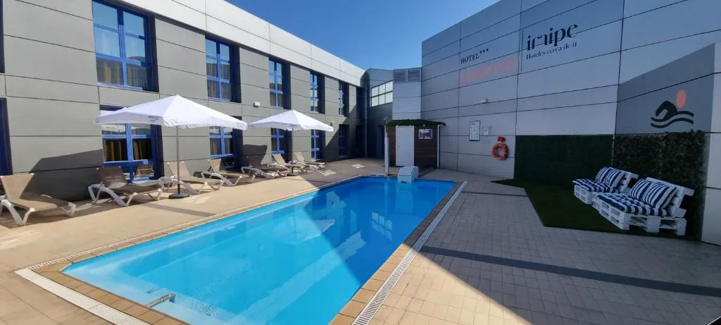Piscina exterior con tumbonas junto al hotel