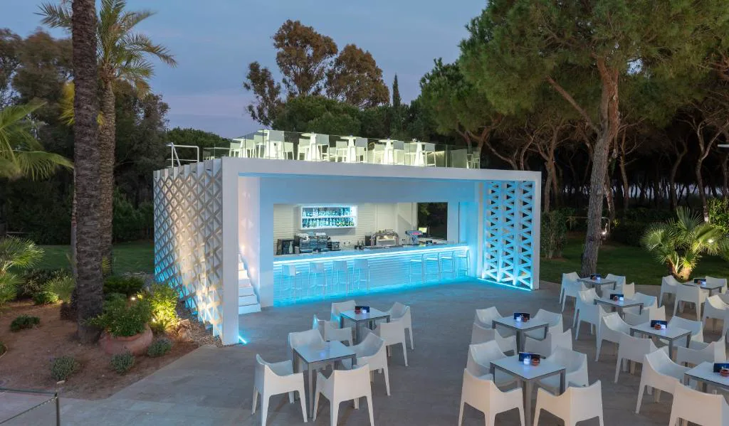 Bar acristalado entre pinos junto a las mesas de la terraza
