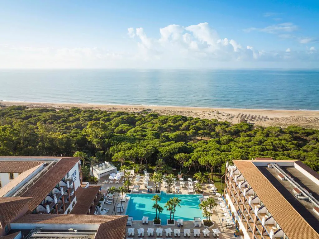 Vista aérea del hotel entre pinares, frente a la playa
