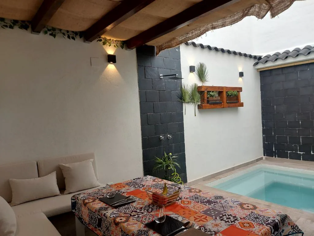 Piscina pequeña con tumbona y patio de paredes negras