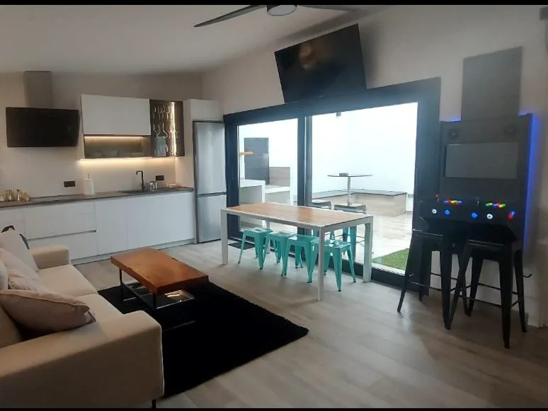 Salón con mesa y ventanales sobre el patio