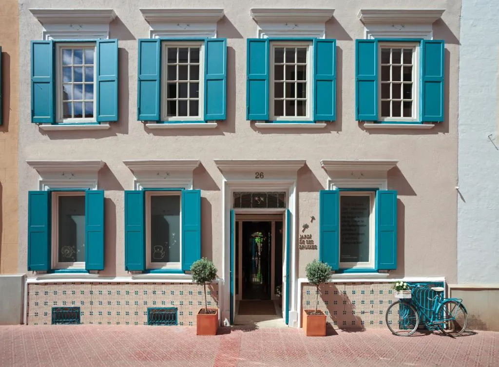 Fachada de ventanas turquesa de Jardí de Ses Bruixes, casa señorial del siglo XVIII en Mahón, Menorca