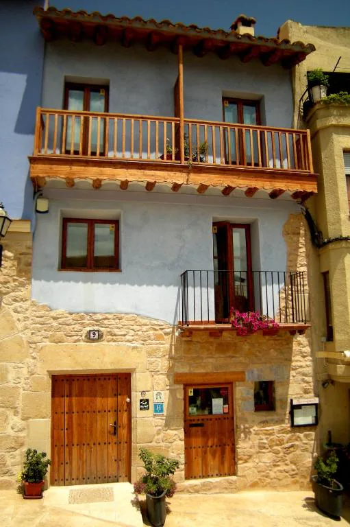 Fachada de casa de pueblo con balcón de madera