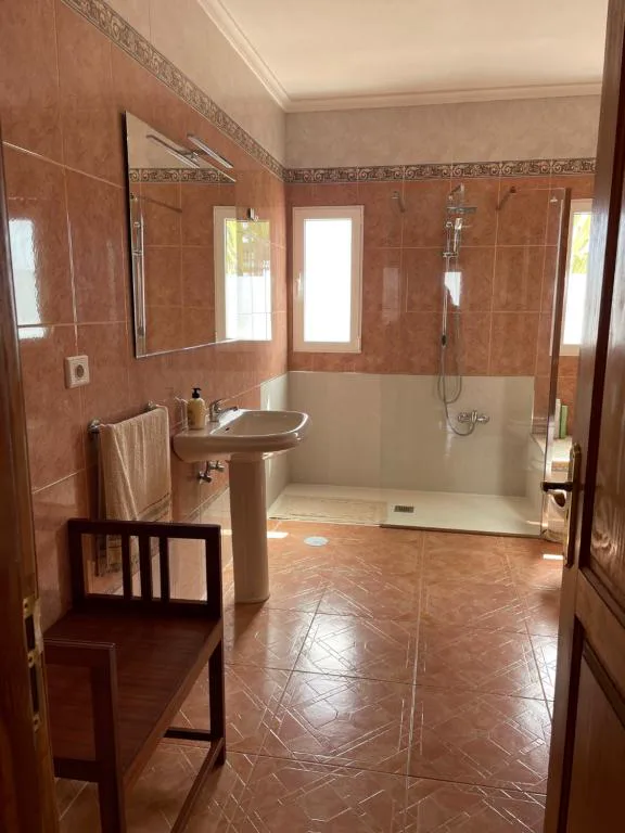 Baño con plato de ducha amplio y azulejos en tonos tierra, La Caldereta Casa Rural