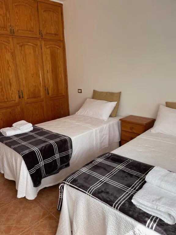 Dormitorio con dos camas individuales y armario de madera maciza, La Caldereta Casa Rural