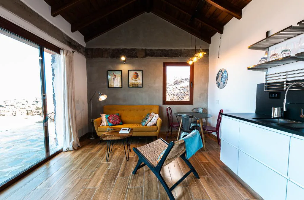 Salón con sofá amarillo y puerta acristalada abierta a la piscina y el mar, La Candia y el Mar