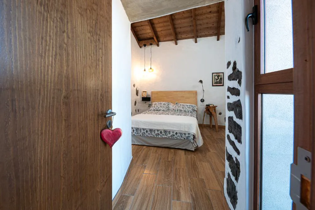 Dormitorio con techo de madera vista y cabecero claro, La Candia y el Mar