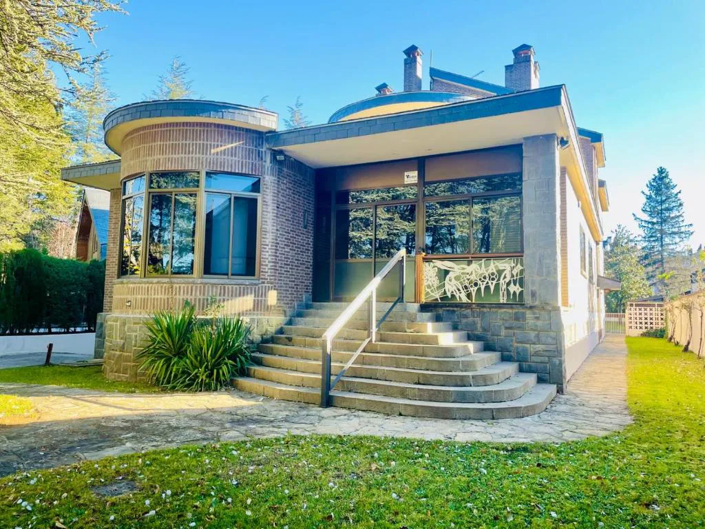 Casa de piedra y cristal con escalera de entrada