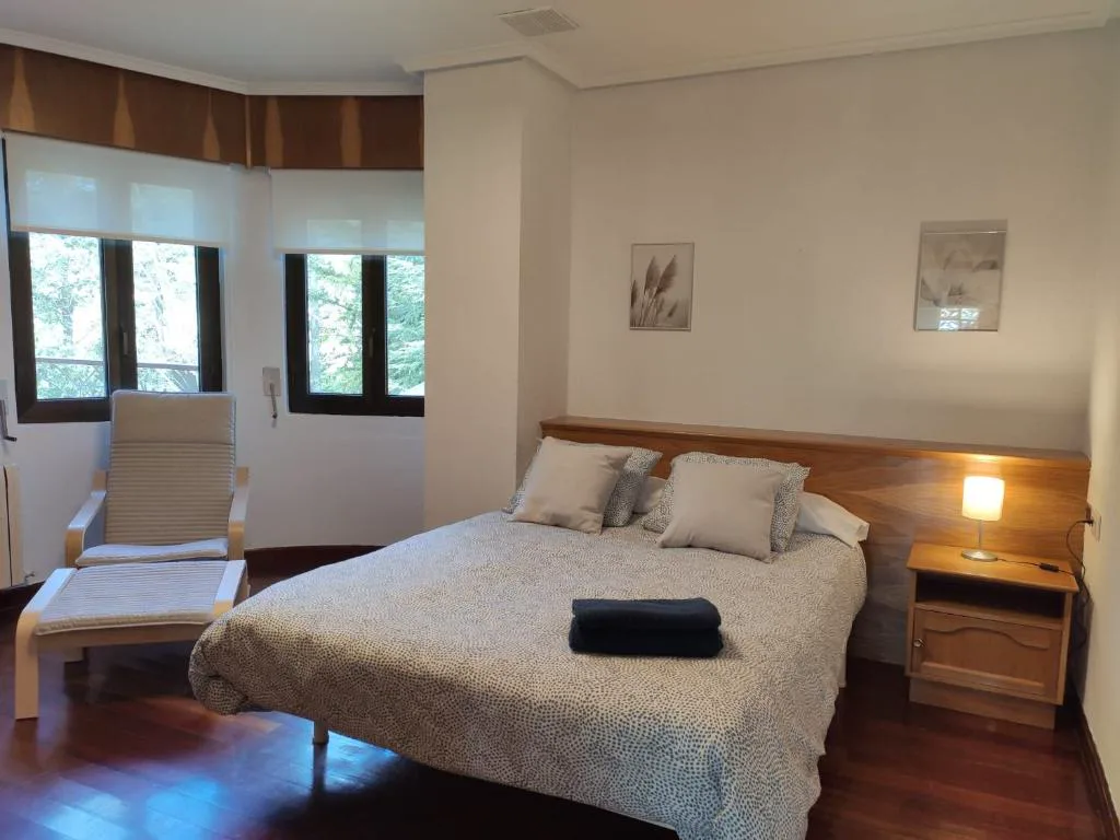 Habitación con cama grande y ventanales