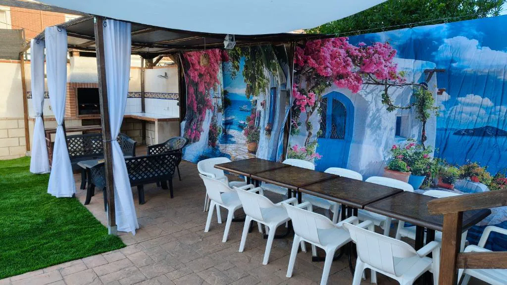 Mesa larga con sombrilla y mural de flores