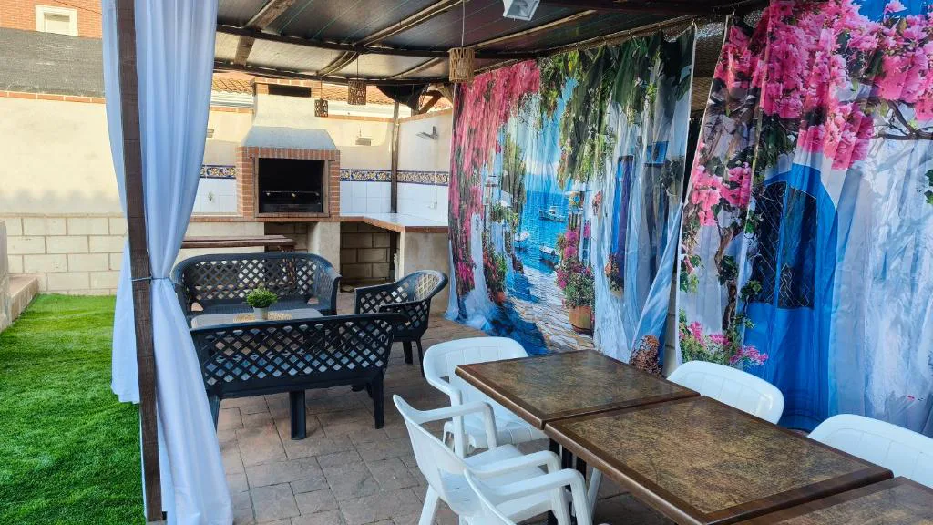 Patio con mural, sombrilla y mesas