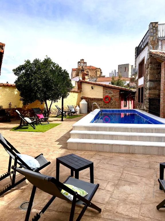 Piscina azul entre casas del pueblo vista desde arriba