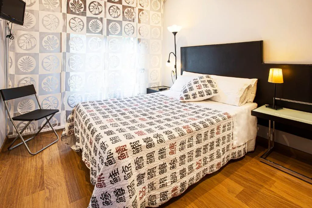Habitación con cama doble, cabecero estampado y suelo de madera