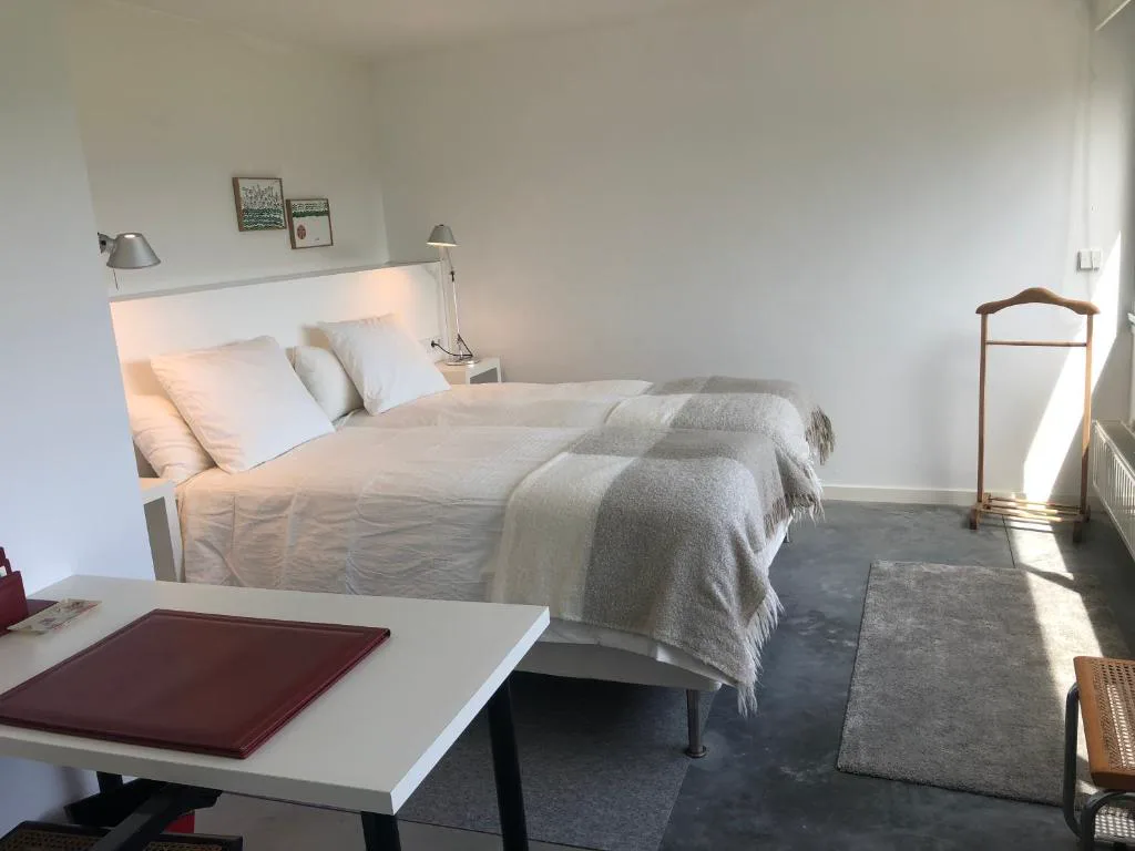 Dormitorio con dos camas, mesa de estudio y armario de madera