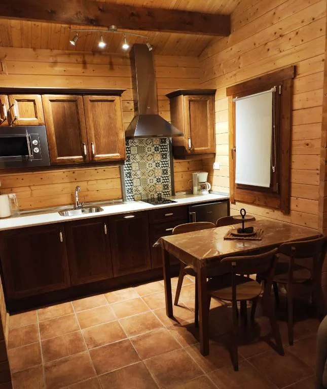 Cocina de madera con mesa y encimera
